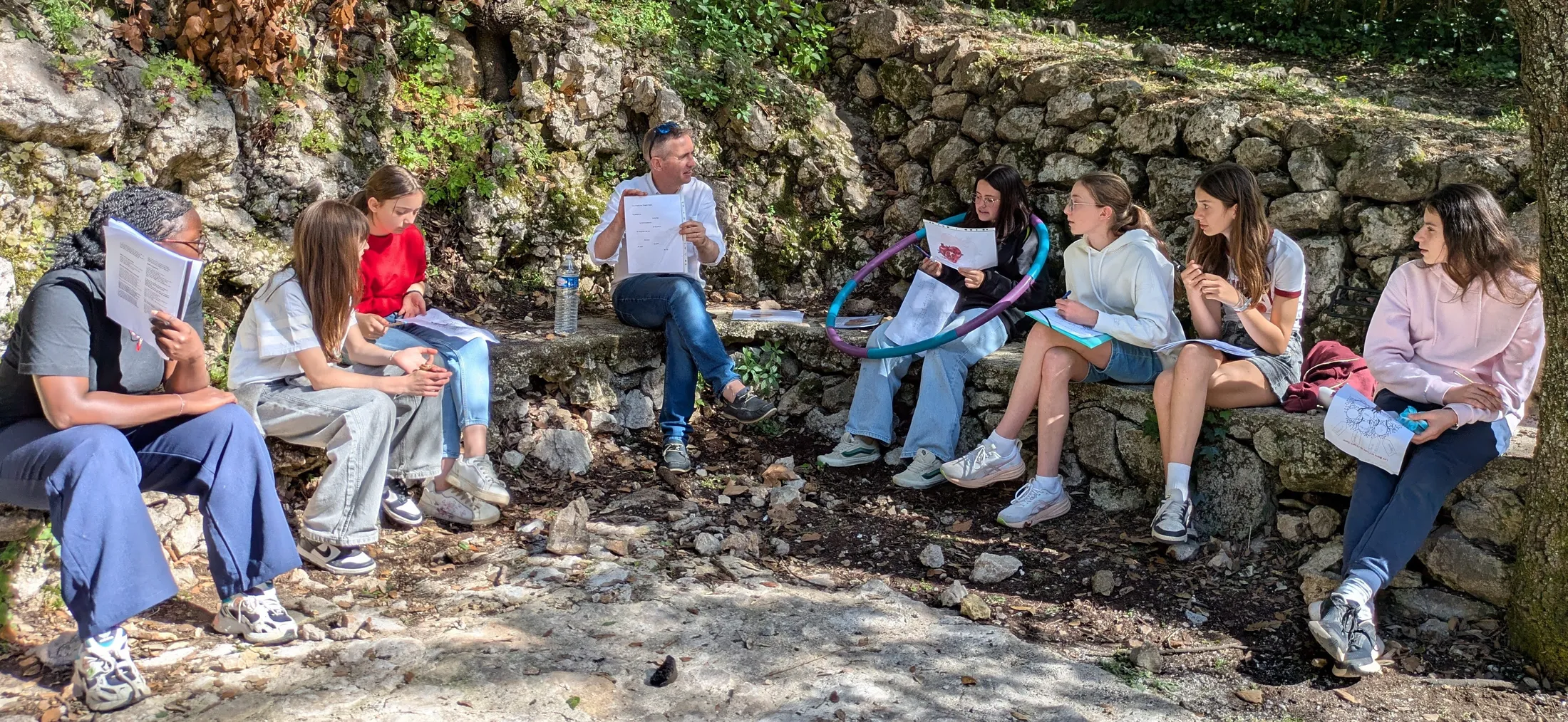 Un groupe de l'aumônerie réuni en plein air autour de son animateur